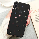 a woman holding a phone case with hearts on it