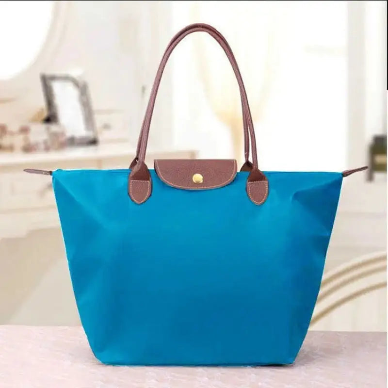 a blue bag with brown handles and handles