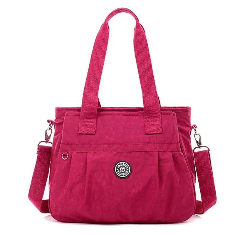 a pink handbag with a small logo on the front