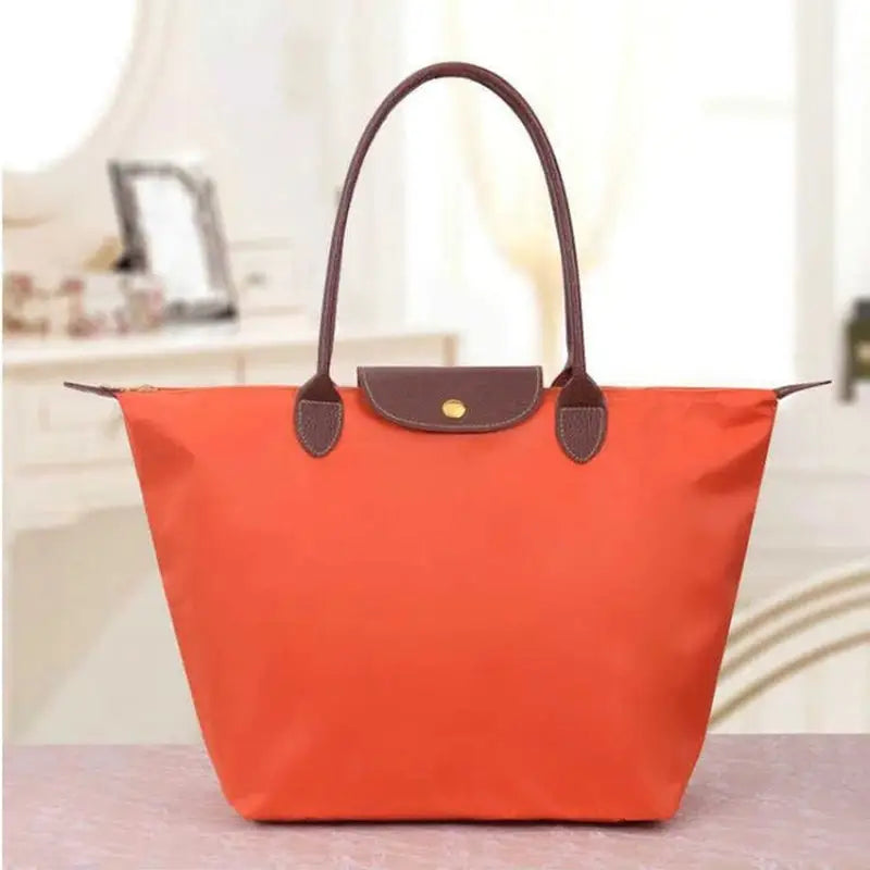 a red and brown handbag on a table