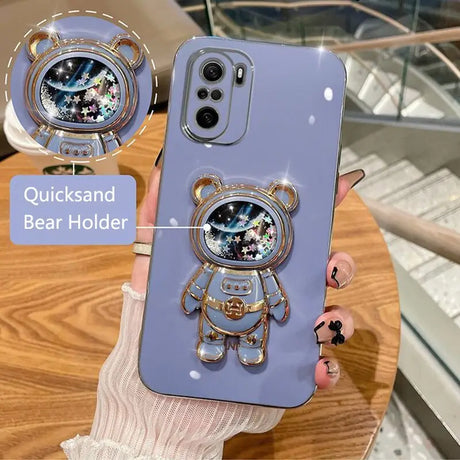 a person holding a phone case with a bear