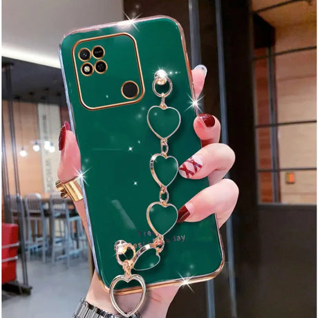 a close up of a person holding a green phone case with a heart and keychain