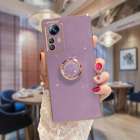 a woman holding a purple phone case with a ring on it