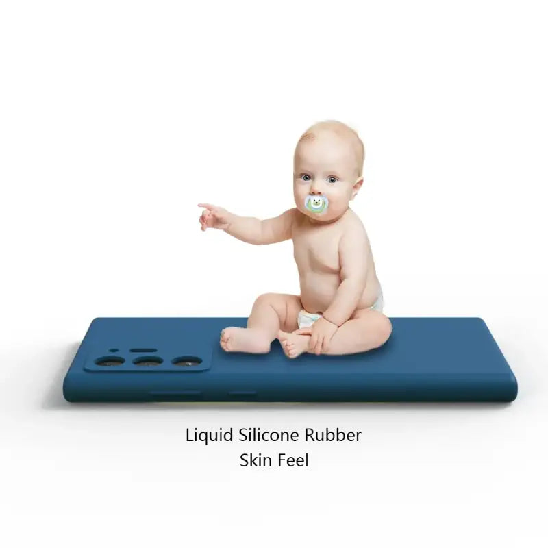a baby sitting on a blue surface with a pac