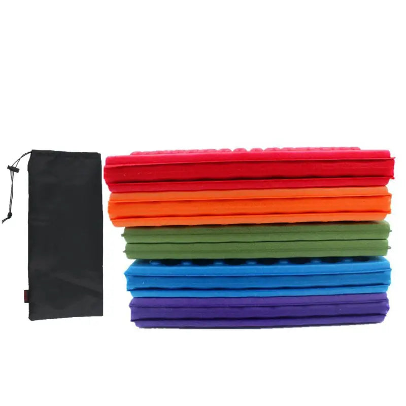 a stack of colorful towels and a black bag