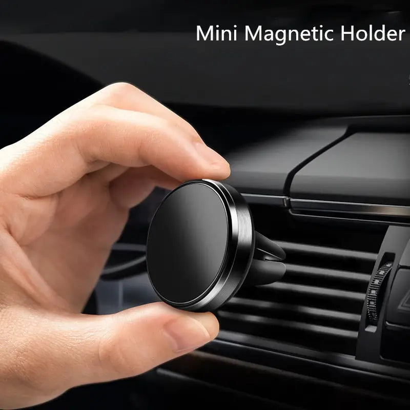 a close up of a person holding a black car air vent holder