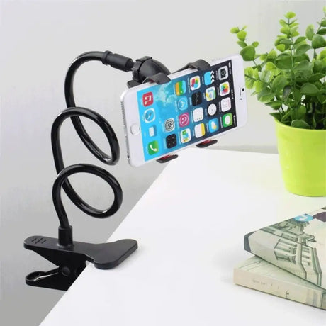 a phone holder on a desk next to a plant