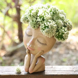 a ceramic sculpture of a girl with flowers in her hair