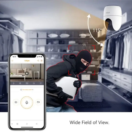 A man in a black hood and hoodie is using a smartphone to scan a home security camera