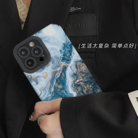 A man in a suit holding a phone case