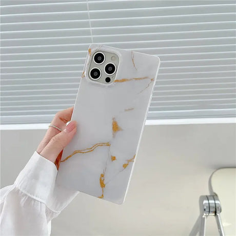 a woman holding a white marble phone case