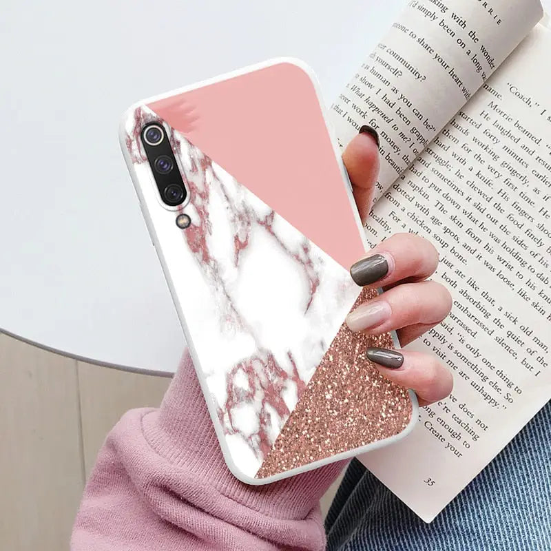 a woman holding a pink and white marble phone case