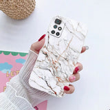 a woman holding a phone case with marble pattern