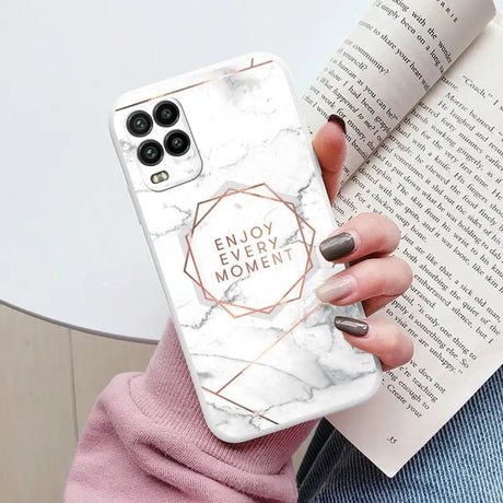 a woman holding a white marble phone case with the words enjoy me