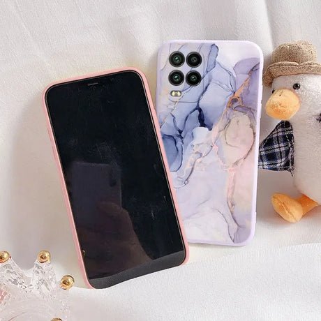 a phone case with a marble pattern and a teddy bear