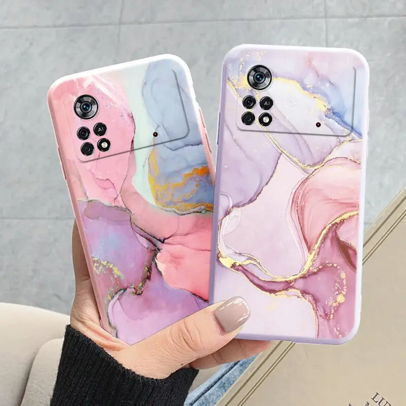 a woman holding a phone case with a pink and blue marble pattern