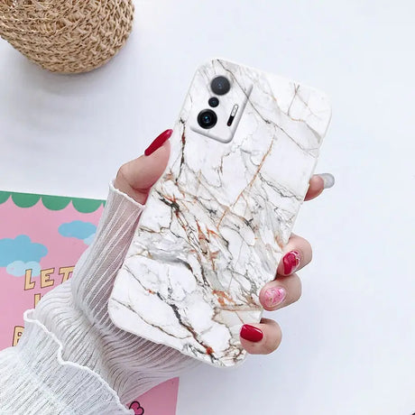 a woman holding a phone case with marble pattern