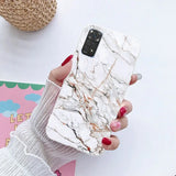 a woman holding a phone case with marble pattern
