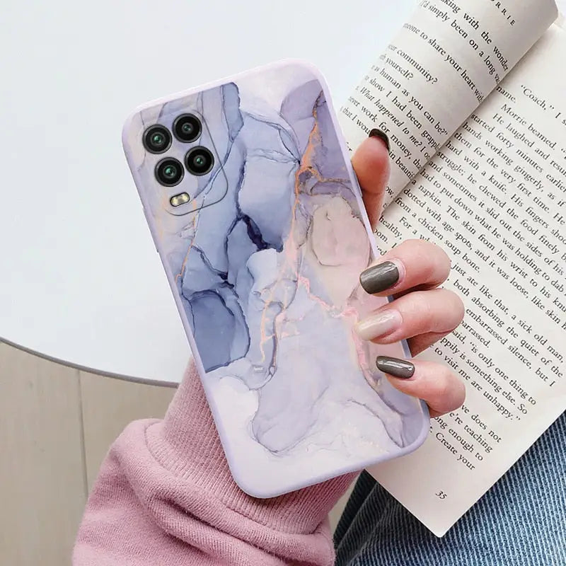 a woman holding a book and holding a phone case