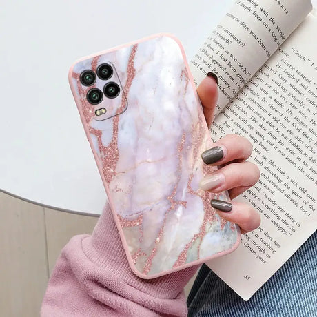 a woman holding a pink marble phone case