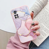 a woman holding a phone case with a pink marble pattern