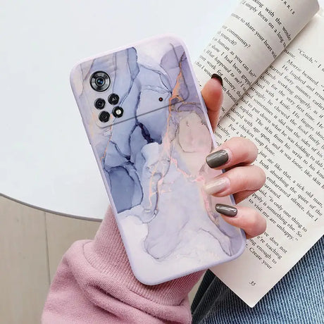 a woman holding a book and a phone case