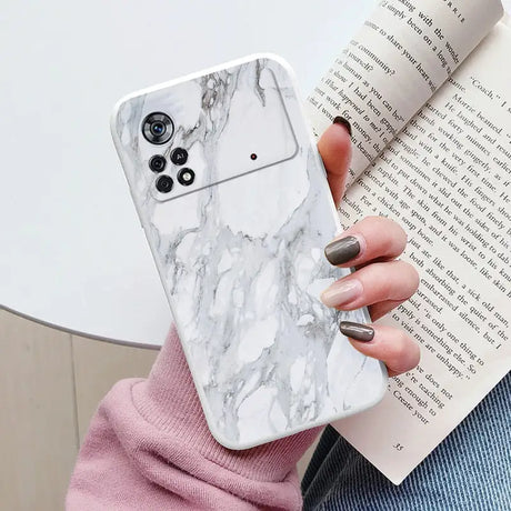 a woman holding a white marble phone case