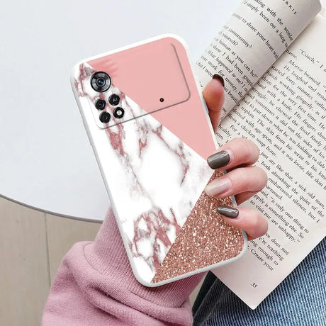 a woman holding a pink and white marble phone case