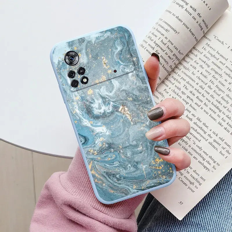 a woman holding a book and a blue marble case