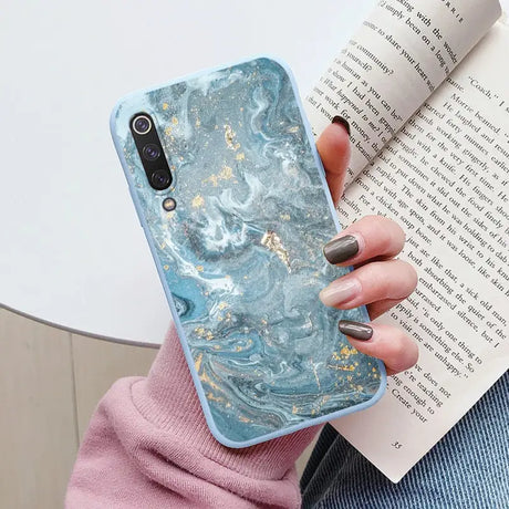 a woman holding a book and a phone case