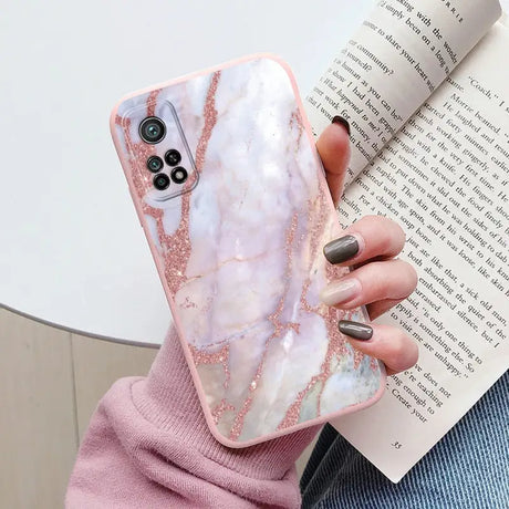 a woman holding a pink marble phone case