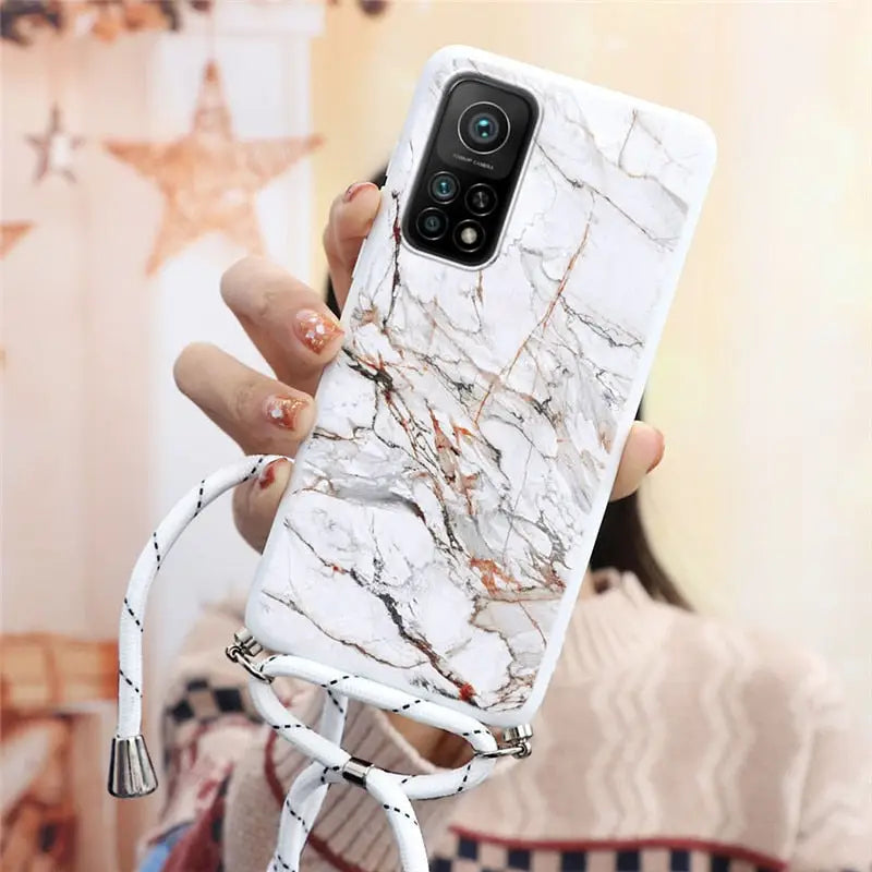 a woman holding a white phone case with marble pattern