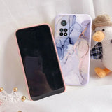a phone case with a marble pattern and a teddy bear