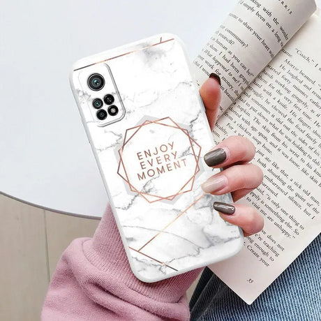 a woman holding a white marble phone case with the words enjoy me