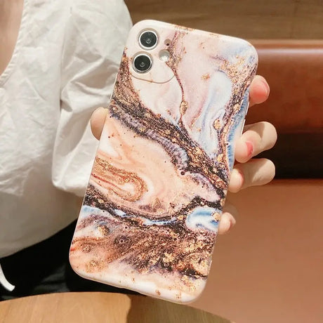 a woman holding a phone case with a marble pattern