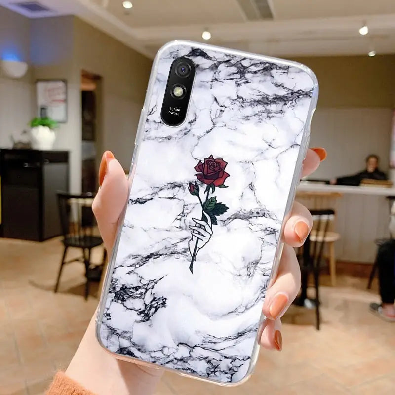 a woman holding a white marble phone case