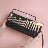 a woman holding a black makeup brush case