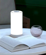 a table with a lamp and a book on it