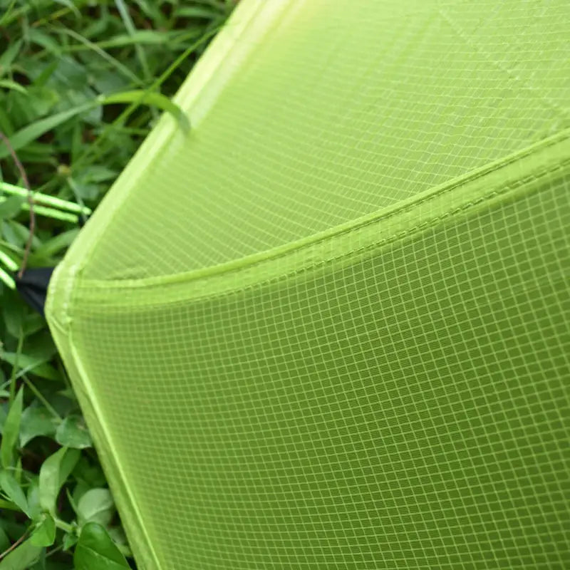 a green chair sitting in the grass