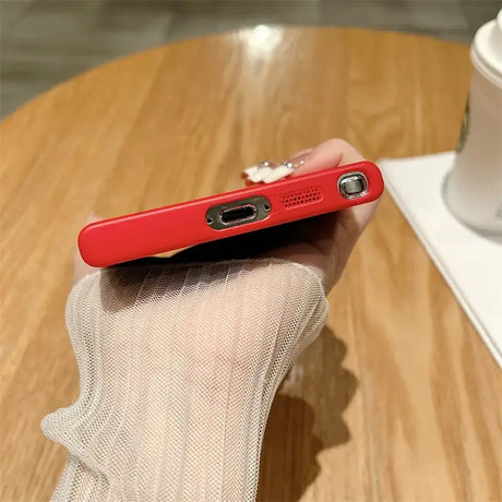 a person holding a red phone in their hand