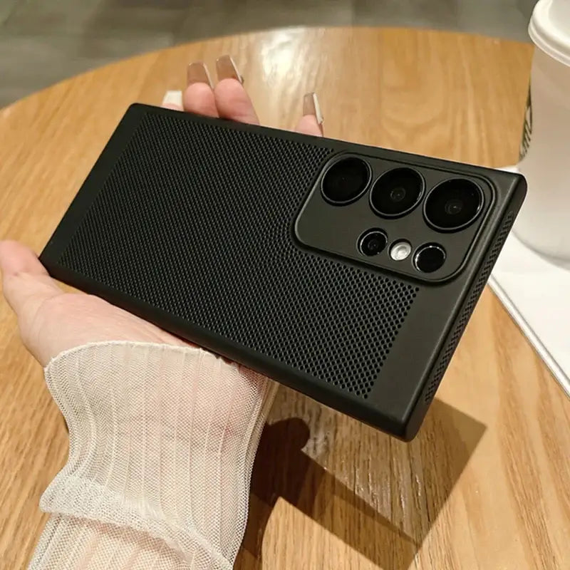 a hand holding a black phone case