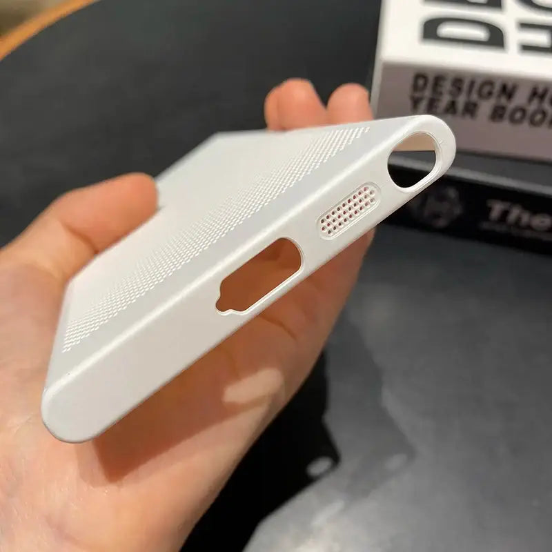a hand holding a white iphone case