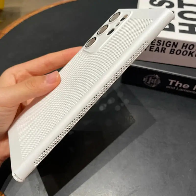 a hand holding a white iphone case