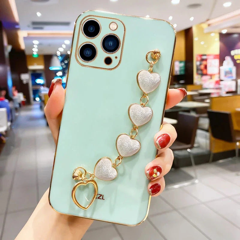 Mint green iPhone case adorned with a decorative gold chain of heart-shaped charms.