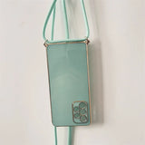 Mint green phone case with a crossbody strap and decorative camera lens design.