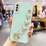 Mint green smartphone case adorned with a decorative chain of pearlescent heart charms.