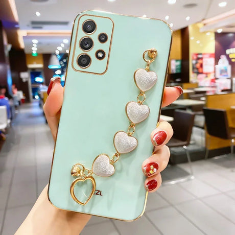 Mint green smartphone case adorned with a decorative chain of pearlescent heart charms.