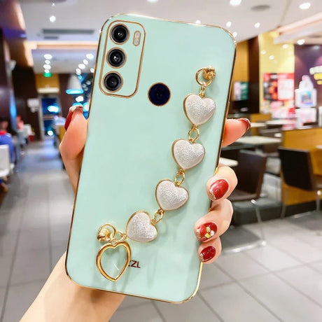 Mint green smartphone with a decorative heart-shaped charm bracelet attached.