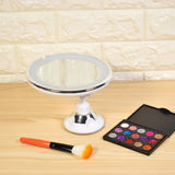 a mirror and makeup brush on a table