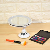 a mirror and makeup brush on a table